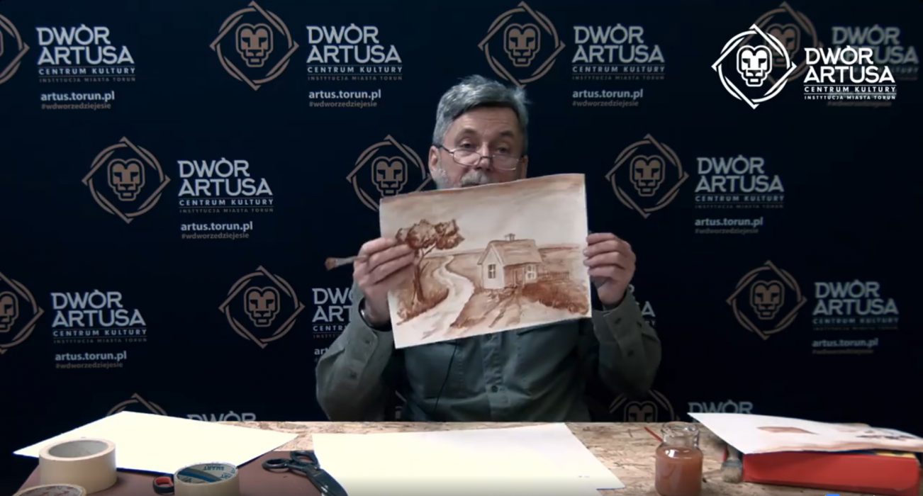 Zbigniew Przybysz prezentuje obraz namalowany techniką lawowania