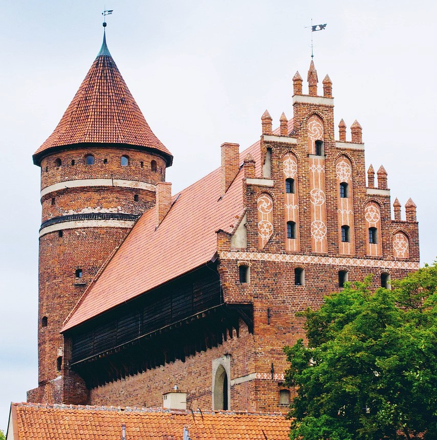 Fragment gotyckiego zamku z czerwonej cegły z basztą