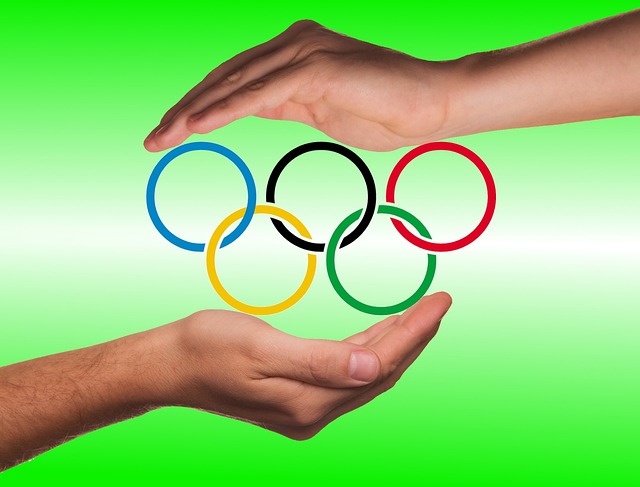 koła olimpijskie między dłońmi