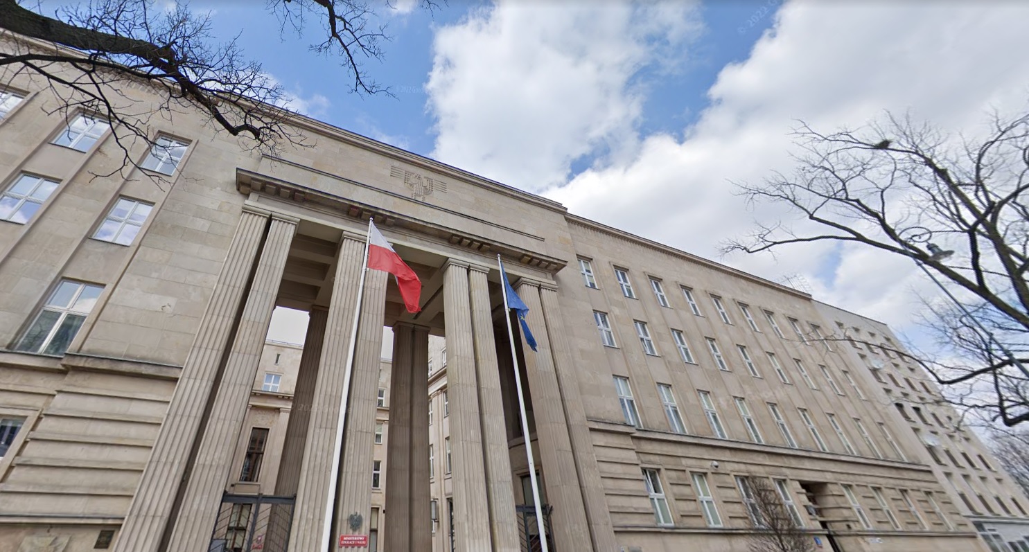 Budynek Ministerstwa Edukacji Narodowej i Nauki w Warszawie. Na masztach wywieszone: flaga narodowa i Unii Europejskiej.