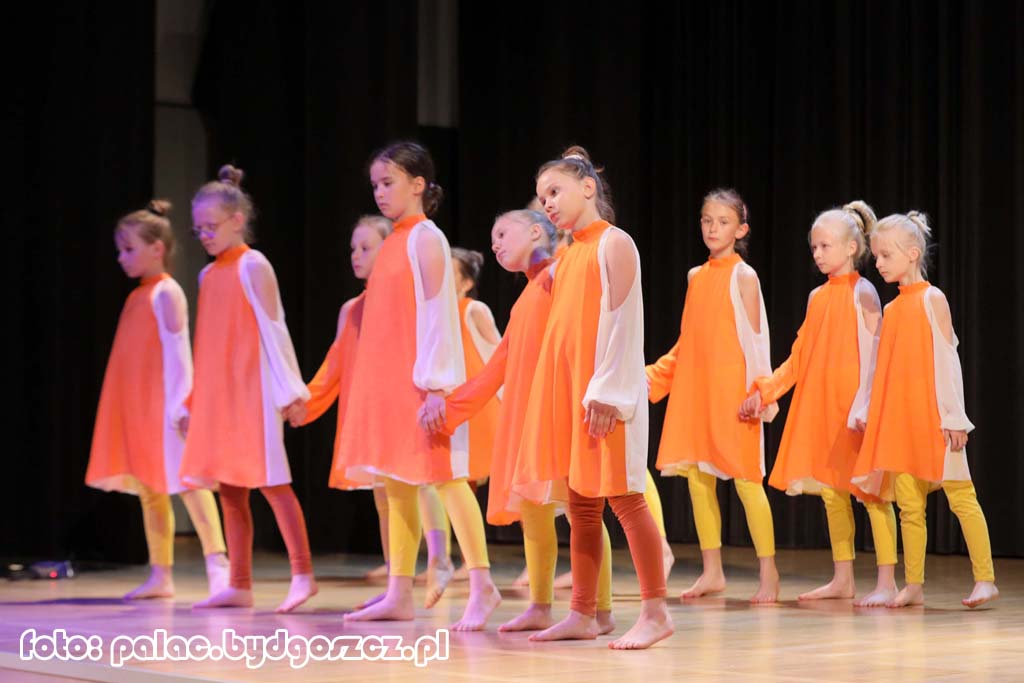 Grupa dziewczynek w strojach scenicznych podczas występu tanecznego.