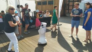 Zwiedzający przyglądają się robotowi przy stanowisku Stowarzyszenia ROBOproject.