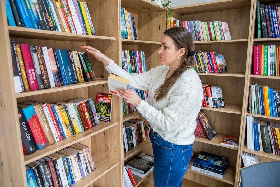 Kobieta przegląda książki na półkach