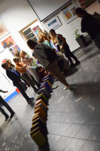 uczestnicy układają domino z książek
