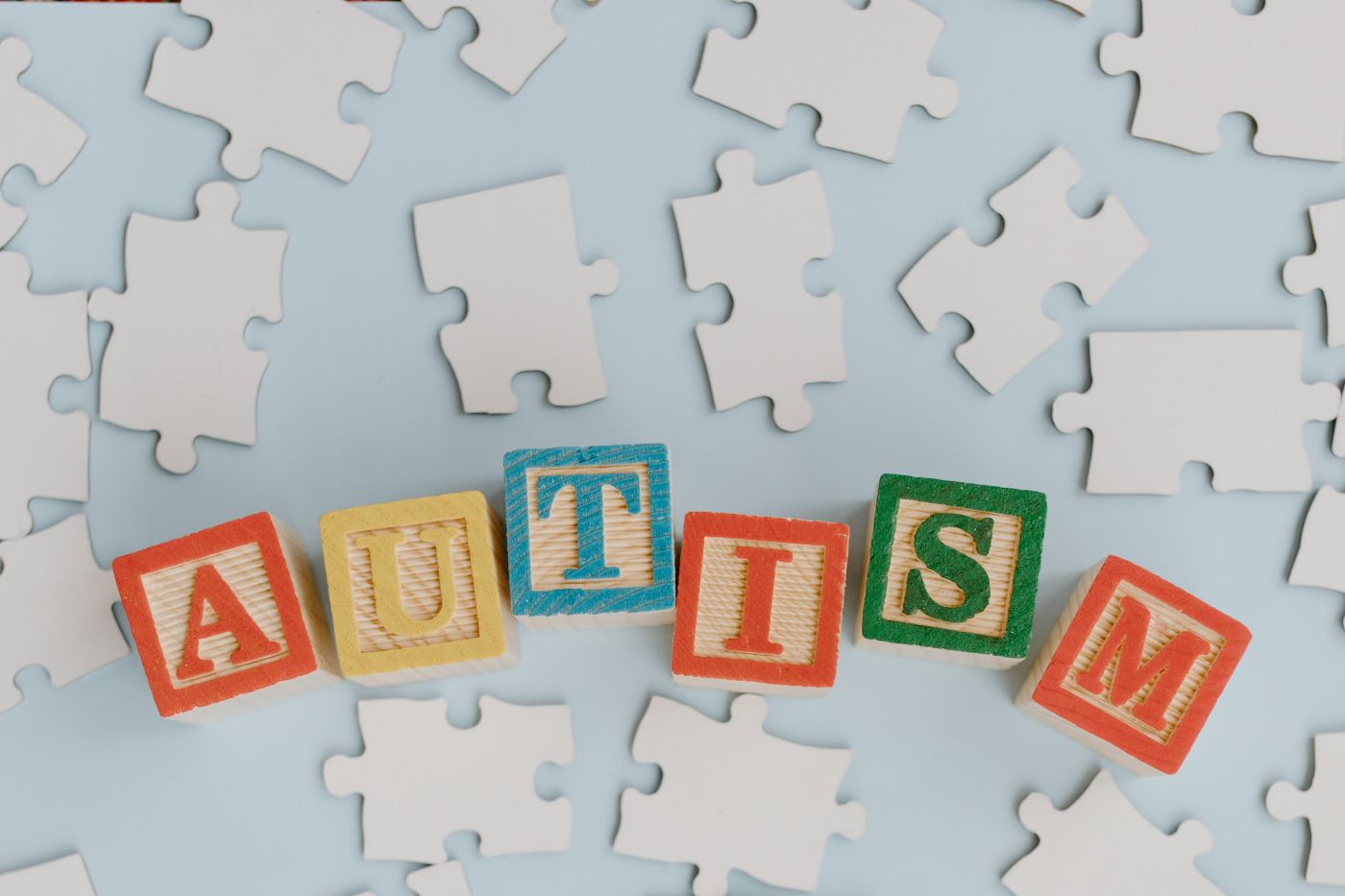 Rozsypane puzzle oraz kostki ułożone w słowo "Autism".