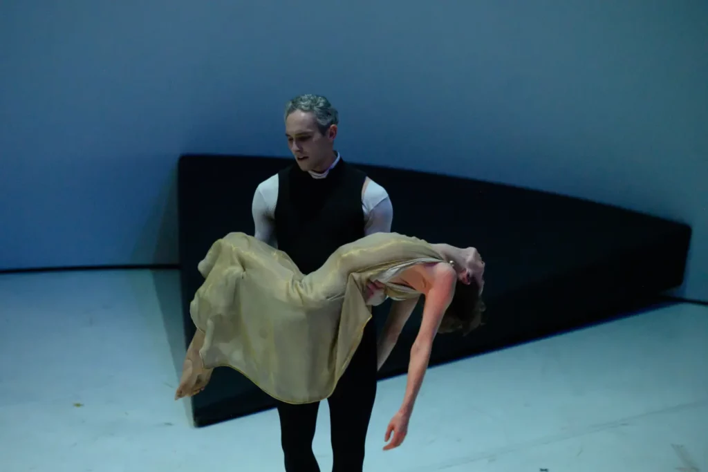 Na scenie teatru mężczyzna niesie zemdloną kobietę