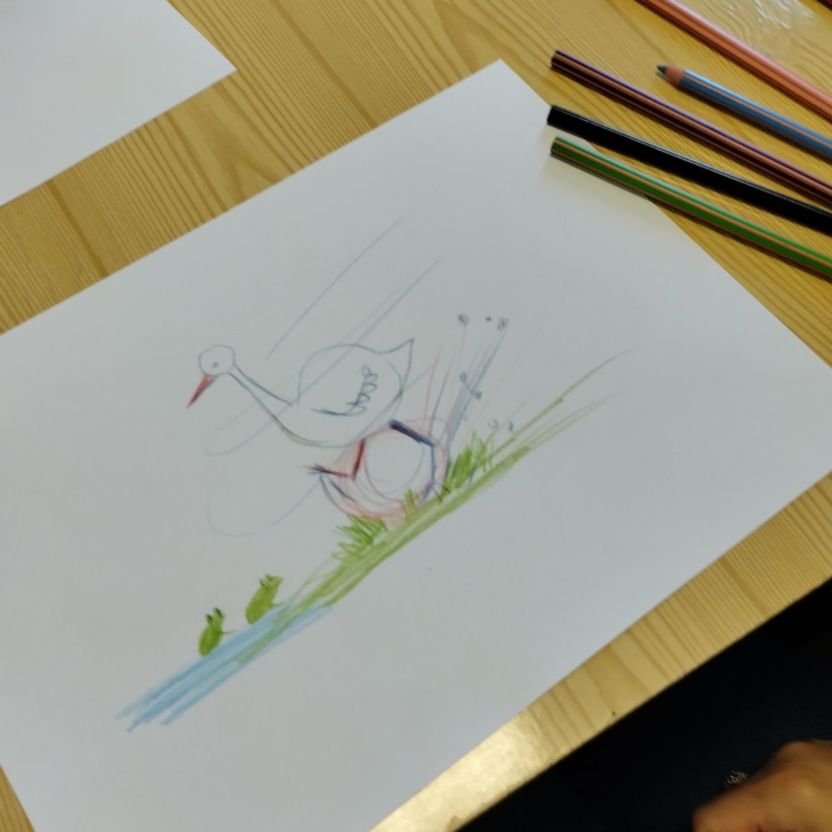 Dziecięcy rysunek ptaka w ruchu, biegnącego po trawie.