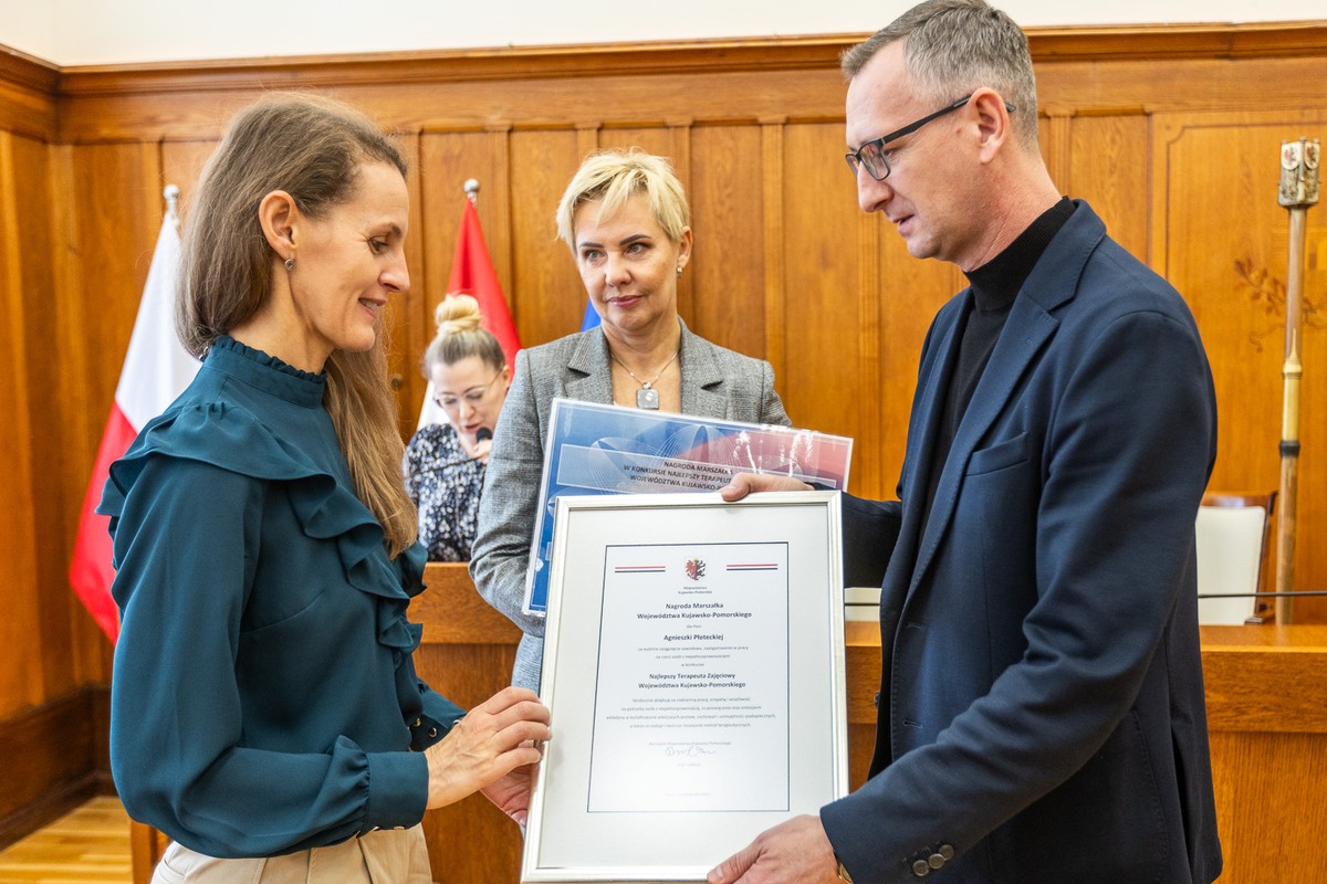 gala wręczenia nagród w sali Sejmiku Województwa, mężczyzna wręcza kobiecie dyplom w ramce
