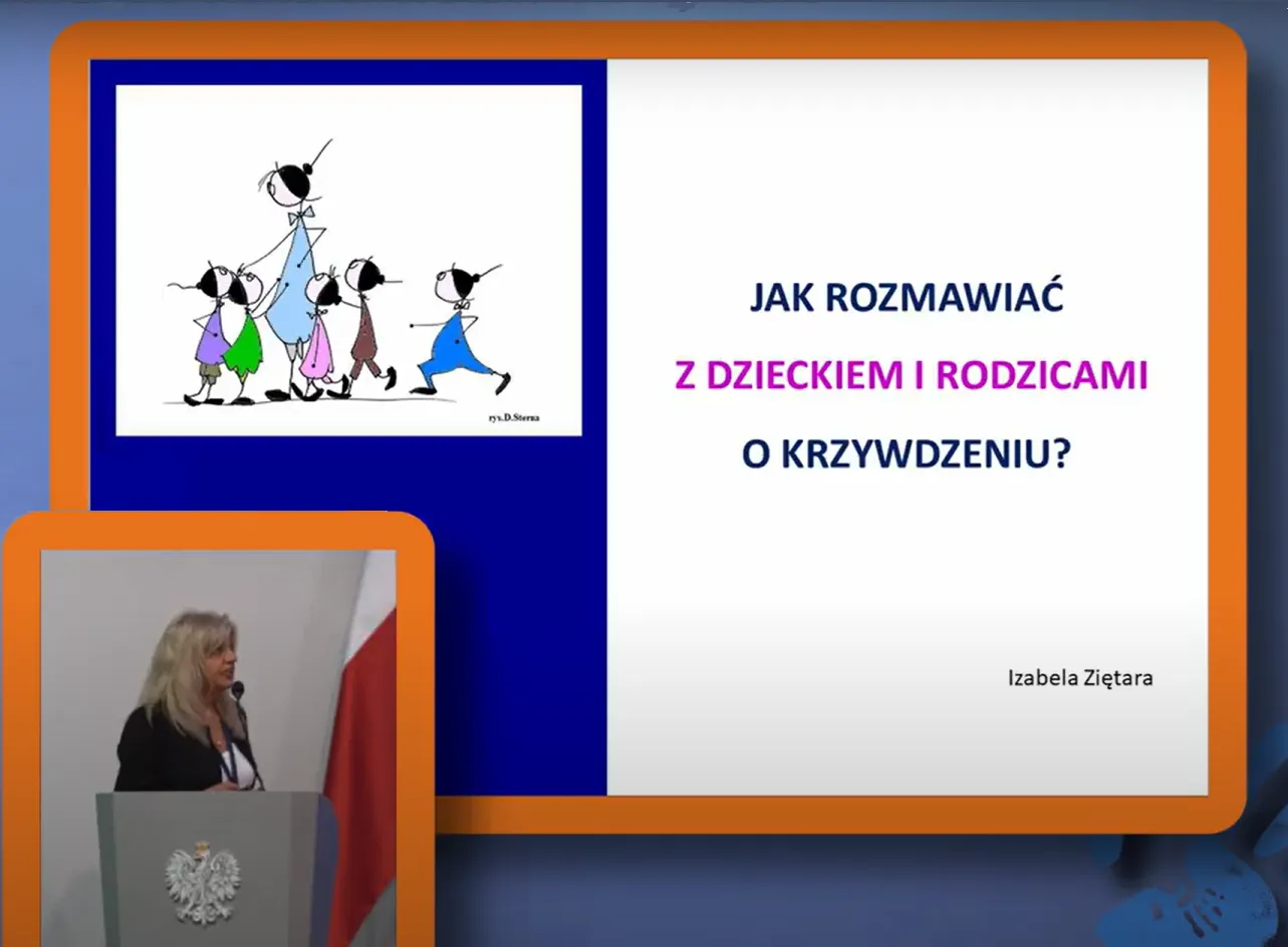 Prelegentka przy mównicy z mikrofonem oraz ekran z wyświetlonym slajdem tytułowym wystąpienia: Jak rozmawiać z dziećmi i rodzicami o krzywdzeniu?